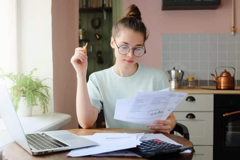 woman with pencil looking at bills